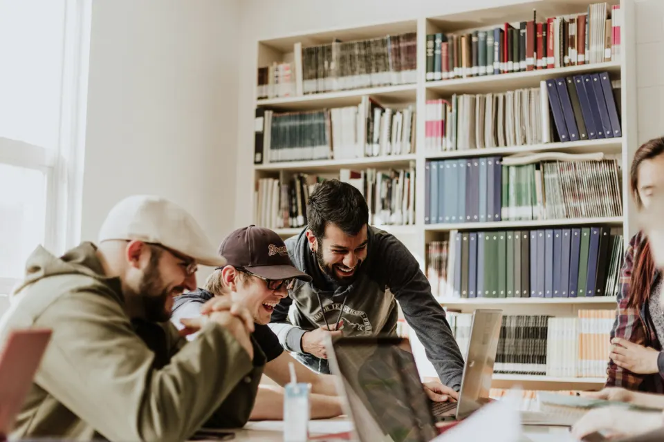 Grupo de personas compartiendo ideas frente a una computadora